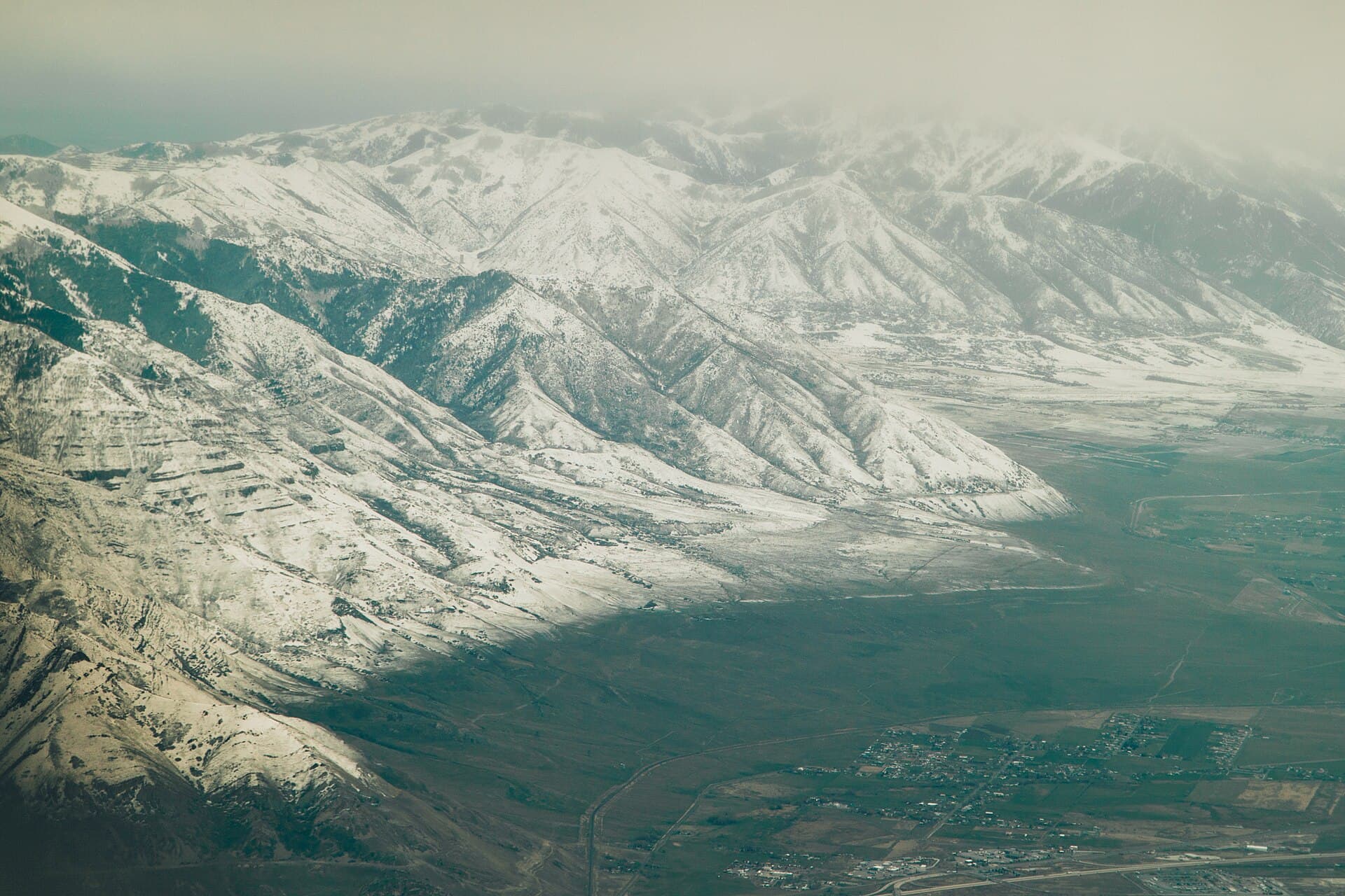 Vista aérea de la nieve en las montañas Oquirrh sobre el fondo del valle en marzo